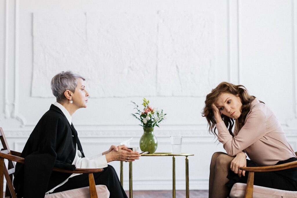 Man and Woman Sitting on Brown Wooden Chair