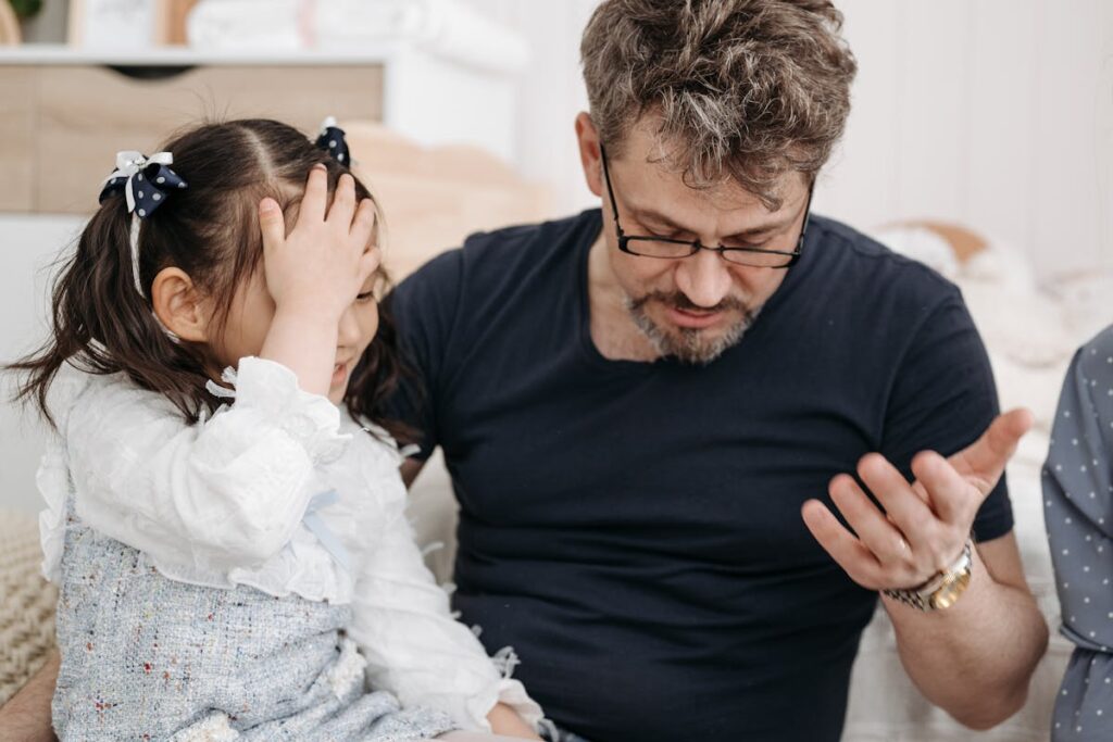 Smiling Little Girl Facepalming Because Her Dad Drops Something